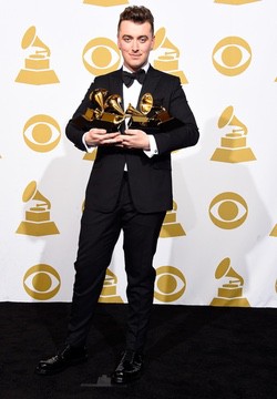 Sam Smith sosteniendo sus Grammys. Sam Smith posando a las cámaras en los Grammy.