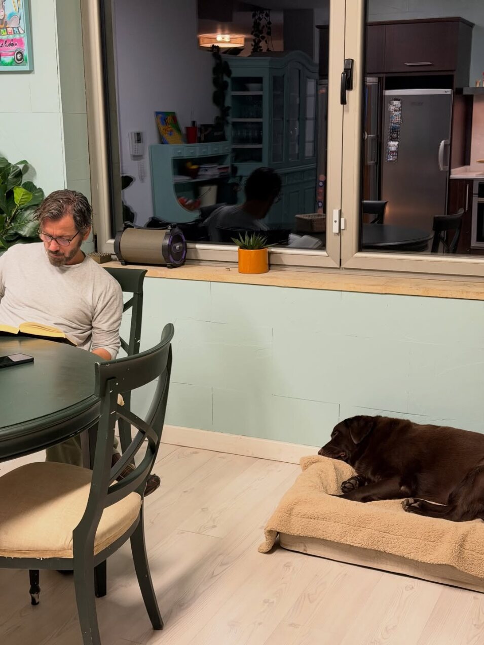 Quique Sánchez Flores leyendo un libro en la cocina junto al perro de Blanca Romero | Foto: Intagram
