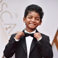 Sunny Pawar colocándose la pajarita en la alfombra roja de los Premios Oscar 2017