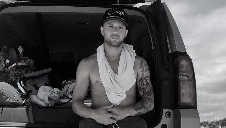 Ryan Phillippe en la playa apoyado sobre un coche