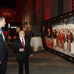 El Rey Felipe mirando una foto en la que aparece como abanderado español en Barcelona 92