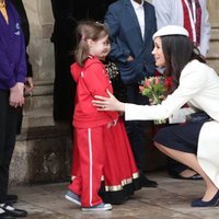 Meghan Markle se agacha para hablar con una niña en el Día de la Commonwealth 2018