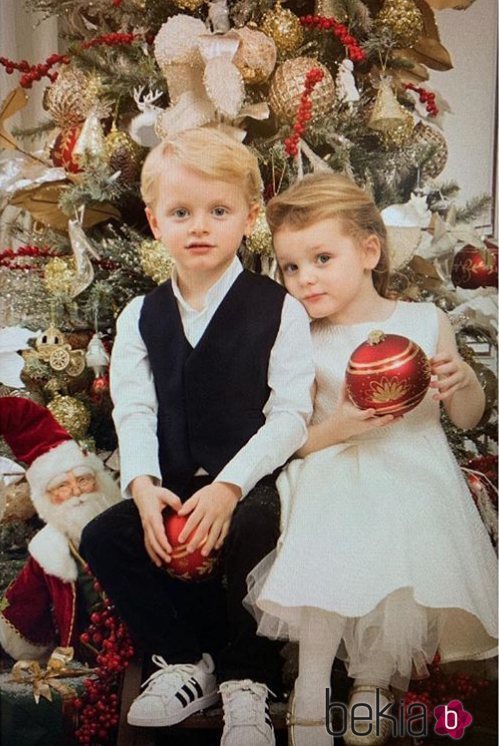 Jacques y Gabriella de Mónaco posando frente a un árbol de Navidad