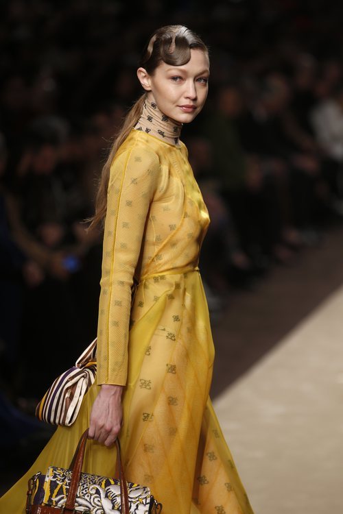 Gigi Hadid con un vestido amarillo superpuesto a un body en el desfile otoño/invierno 2019/2020 de Fendi