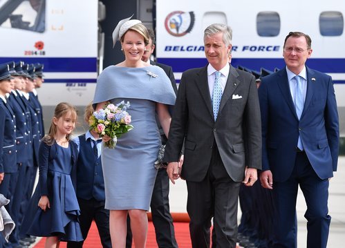 La Reina Matilde de Bélgica con un vestido con capa de color lila aterriza en el aeropuerto de Sajonia