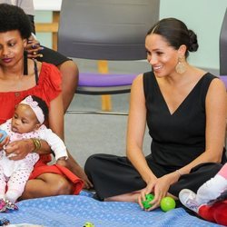 Meghan Markle con una mujer y unas niñas en su visita a Mothers 2 Mothers en Sudáfrica