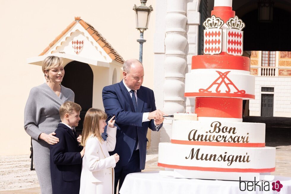 Alberto de Mónaco cortando su tarta de cumpleaños ante Charlene de Mónaco y sus hijos