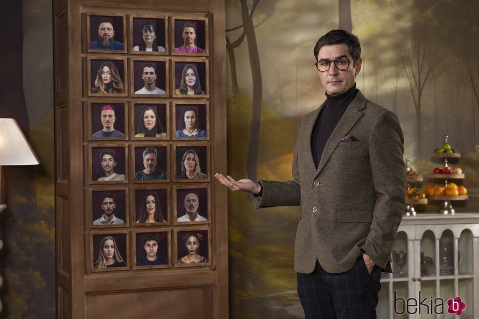 Juanra Bonet ante los retratos de los participantes de 'Traitors España'