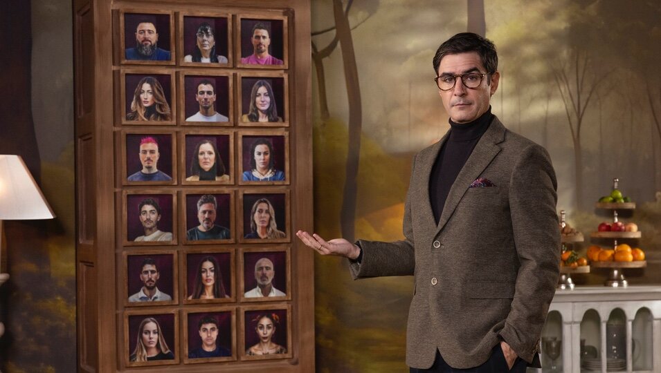Juanra Bonet ante los retratos de los participantes de 'Traitors España'