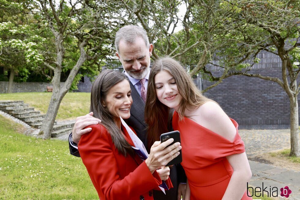 Los Reyes Felipe y Letizia y la Infanta Sofía mirando el móvil en la graduación de la Infanta Sofía