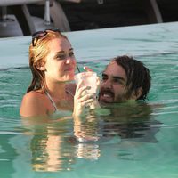 Miley Cyrus en bikini se divierte en la piscina con un amigo