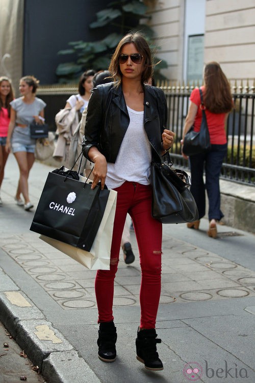 Irina Shayk con pantalones rojos, chaqueta de cuero negra y sneakers de Isabel Marant