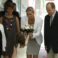 Charlene recibe un ramo de flores bajo la atenta mirada de Alberto de Mónaco