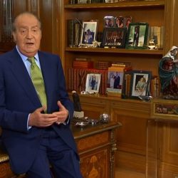 El Rey Juan Carlos, sentado sobre la mesa en su discurso de Navidad 2012