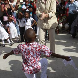 La Infanta Elena aplaude a un niño durante su viaje a Ecuador