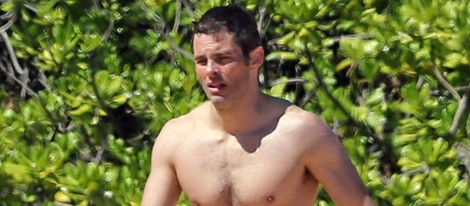 James Marsden en bañador caminando por una playa de Hawaii