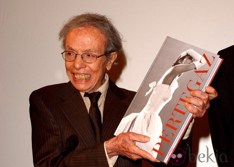 El diseñador Manuel Pertegaz posa con el libro que recoge su trabajo en la moda