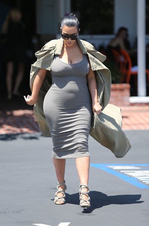 Kim Kardashian con vestido gris y gabardina en su segundo embarazo