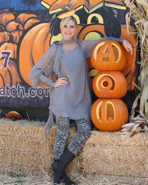 Heidi Klum con blusón y vaqueros junto a una calabaza gigante
