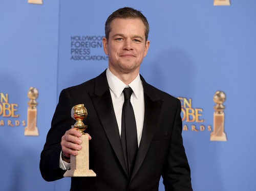 Matt Damon posando con su premio de los Globos de Oro 2016