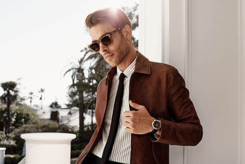 Jon Kortajarena con gafas de sol y traje sastre marrón y ella con vestido de volantes a rayas de Salvatore Ferragamo para la colección 'The Splendor of Lif