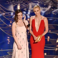 Emily Blunt y Charlize Theron dando un estatuilla gala de los Premios Oscar 2016