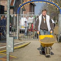 El Rey Guillermo Alejandro de Holanda cargando una carretilla con arena