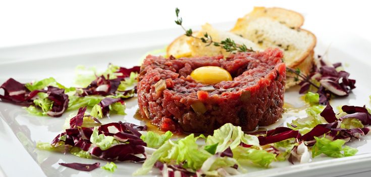 Tartar de atún acompañado de huevo y rebanadas de pan